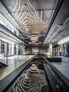 the inside of an office building with water running down it's floor and lights hanging from the ceiling