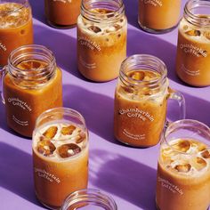 several jars filled with liquid sitting on top of a purple table