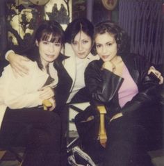 three women sitting next to each other on a couch