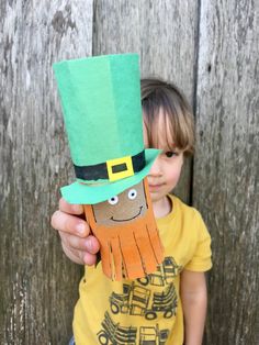 a young child holding up a paper lepreite