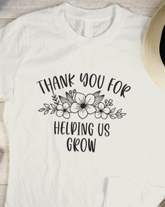 a white t - shirt with the words thank you for helping us grow on it