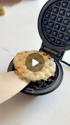 a waffle being cut with a knife on top of the waffles that have been cooked