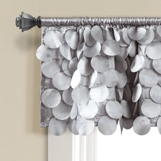 a curtain with silver circles hanging from it's valance in front of a window