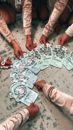 several children are sitting on the floor and playing with paper cutouts that say hello kitty