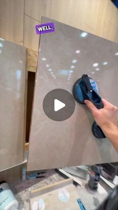 a person using a sanding machine to clean marble