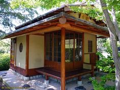 a small wooden building sitting under a tree