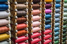 many spools of thread are lined up on the wall in front of each other