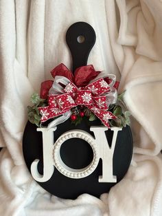 a black and white sign that says joy with red bows on it's head