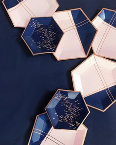 four blue and pink plates with writing on them sitting on top of a black surface