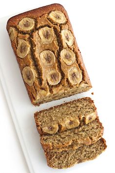 two slices of banana bread are on a white platter and one is cut in half