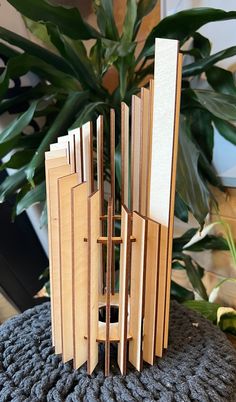 a wooden sculpture sitting on top of a table next to a potted plant