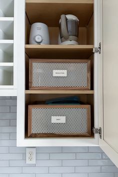 an open cabinet with two bins on the bottom