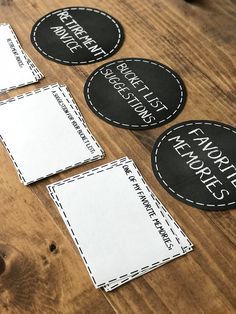 three black and white labels on a wooden table with some paper cut out to spell the words