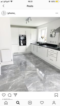 a kitchen with white cabinets and grey marble flooring on the bottom right hand corner