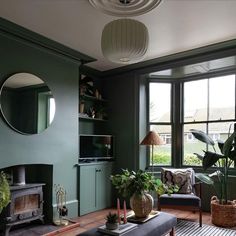 a living room filled with furniture and a fire place in front of a large window