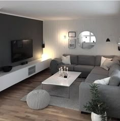 a living room filled with furniture and a flat screen tv on top of a wooden floor