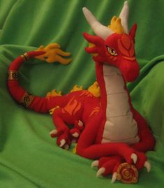 a red dragon sitting on top of a green blanket