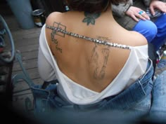 a woman with a cross tattoo on her back