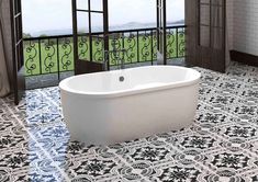 a bath tub sitting in the middle of a bathroom next to a window and tiled floor