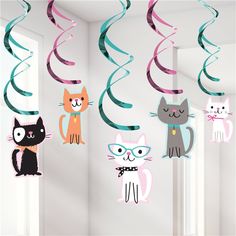 a room filled with lots of different colored cats hanging from the ceiling