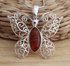 This is 925 Sterling Silver Pendant & Genuine Baltic Amber .      925 stamped            Amber size: 8 mm x 18 mm            Amber colour: cognac Approx. pendant measures:                 length: 36 mm                width: 40 mm in its widest part Approx. weight: 5.0gr. pendant only.                                         Available on its own or with various length (16-26 Inch ) snake chain, please choose from the drop down menu at the top of the page. Presented in gift box. Thank you for look Classic Amber Necklace As Gift, Amber Hallmarked Necklaces For Gifts, Classic Amber Necklace Gift, Classic Amber Necklace For Gift, Classic Orange Necklace For Gift, Classic Orange Necklace For Gifts, Classic Orange Jewelry As Gift, Classic Orange Jewelry For Gift, Brown Hallmarked Jewelry As Gift