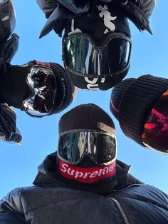 a person wearing ski goggles standing in front of some snowboard helmets and gloves