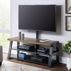 a flat screen tv sitting on top of a wooden stand