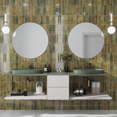 a bathroom with two sinks and mirrors on the wall next to each other in front of a tiled wall