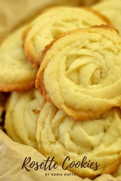 some cookies that are sitting on top of each other in a paper bag with the words rosette cookies written below it