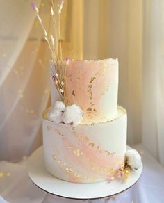 a white and pink wedding cake with gold sprinkles