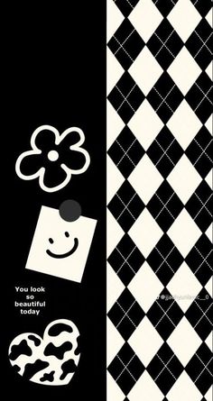 a black and white checkered wallpaper with an image of a smiley face on it