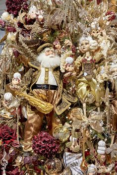 a christmas tree decorated with gold and red ornaments, including santa claus ornament