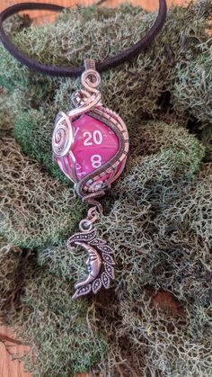 Each pendant is handmade with love and care, each is beautiful and unique. It is a great gift for friends, significant other, or anyone who enjoys handmade jewelry. This wire wrapped Pink/Silver D20 plastic Polyhedral Die is wrapped in enameled colored copper wire. Item details: - 25mm diameter D20 Polyhedral die Pink/Silver swirl with white numbers. - Silver Moon Charm. - Pendant is 3in in height including the dangle. - This pendant comes with 20in black Faux Suede cord. No Extra charge. - 18 g Handmade Pink Fantasy Jewelry, Adjustable Fantasy Necklaces For Gifts, Adjustable Fantasy Necklace As Gift, Adjustable Fantasy Necklace Perfect For Gifts, Adjustable Fantasy Style Necklace Perfect For Gifts, Handmade Fantasy Round Pendant Jewelry, Fantasy Wire Wrapped Jewelry Gift, Fantasy Wire Wrapped Jewelry As Gift, Fantasy Style Handmade Round Pendant Jewelry