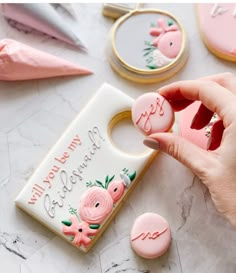 a person is holding some pink decorated cookies