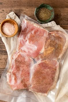 raw pork chops on a wooden table with seasoning