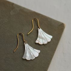 These beautiful Art Deco earrings are pure Mother of Pearl which has been carved into a simple scalloped fan shape. The pearl has an incredible sheen and take on a subtle glow when they catch the light. They are finished with gold plated earwires and are designed to hang just below the earlobe. The length of the earrings is around 45mm (just under two inches). 🖤 FASTER SHIPPING 🖤 Need this fast? We offer a Faster Shipping option here: https://www.etsy.com/uk/listing/100107311/faster-shipping-p Elegant Shell-shaped Jewelry With Ear Wire, Elegant Shell-shaped Wedding Earrings, Gold Shell-shaped Earrings For Wedding, Elegant Shell-shaped Earrings For Gift, White Art Deco Earrings For Anniversary, Gold Art Deco Earrings, Egyptian Necklace, Art Nouveau Earring, Wedding Day Jewelry