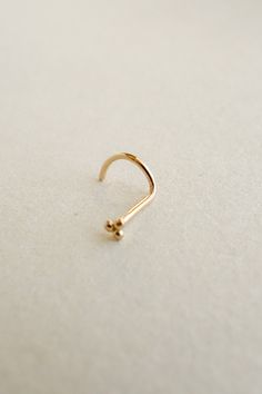 a gold nose ring on a white surface