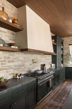 a kitchen with green cabinets and an oven in the center, along with shelves on either side