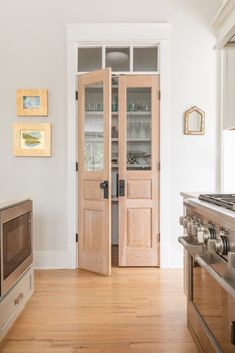 a kitchen with wooden floors and white walls