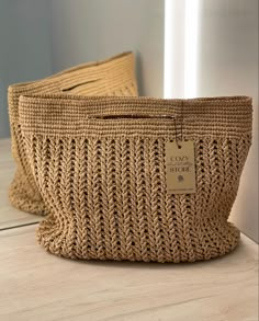 two woven bags sitting on top of a wooden table