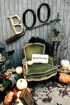 a chair sitting in front of a wall with halloween decorations on it and the word boo spelled out