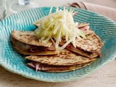 a blue plate topped with quesadillas and cole slaw