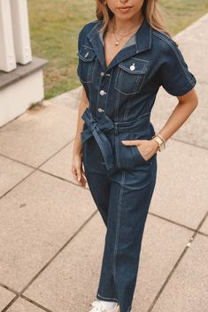 DETAILS    Introducing the perfect addition to your casual wardrobe: our Denim Jumpsuit! With its V-neckline, collared neckline and short sleeves with rolled cuffs, this jumpsuit is sure to become your new go-to.   v neckline  collared  short sleeves with rolled cuff  functional chest pockets  functional buttons down front  belt loops  detachable waist tie  functional side pockets  functional back pockets  straight leg style  unlined   material - 100% cotton    SIZING     model is 5' 8" and wear Short Sleeve Denim Jumpsuit, Blue Playsuit, Satin Dresses Long Sleeve, Black Tie Wedding Guests, White Dress Shoes, Essential Dress, Crop Top Tees, Dresses By Length, Knit Set