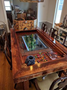 a wooden table topped with a glass top covered in gummy bears