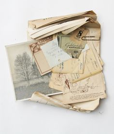 an old envelope full of letters and postcards on a white surface with writing underneath it