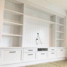 a white bookcase with drawers and shelves in the middle, along with other bookshelves