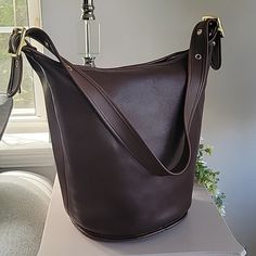 Stunning Deep Mahogany Color In The Largest Size Coach Duffle Bag Made. Made In 1997 In Usa , The Leather Is Soft And In Excellent Vintage Condition. *Inside Zippered Pocket *Original Hang Tag *15" Max Strap Drop With 4 Adjustable Lengths *13"Lx13"Wx9"W *Polished Brass Hardware The Bag Has Been Cleaned And Conditioned And Ready To Wear. Please Note That There Is A Tiny White Mark And Some Minor Discoloration On Part Of The Bottom Rim. Please See All Pictures. Classic Bucket-shaped Bag With Leather Lining, Classic Bucket Shaped Bag With Leather Lining, Classic Bucket Bag, Classic Bucket Shape Shoulder Bag, Classic Coach Bucket Bag For Daily Use, Luxury Coach Bucket Bag For Everyday, Classic Coach Rectangular Bucket Bag, Coach Bucket Hobo Bag, Classic Coach Bucket Bag For Everyday Use