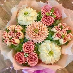 a bouquet of pink and white flowers sitting on top of a table