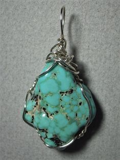 Turquoise Nugget Pendant Wire Wrapped in .925 Sterling Silver Round Wire This inspiring stone offers a few small pebbles of golden pyrite nestled inside a light to medium turquoise-blue and black patterned background. Best worn with blue, green, coral, orange, or red; but quite versatile, and many dark, bright, pastel, and earth tone colors also wear well, especially black, grays, brown, beige/tan, and lavender. A similar color of turquoise will blend, so should be avoided. Some darker purple co Artisan Turquoise Necklace With Large Stone, Turquoise Chrysocolla Necklace With Stones, Turquoise Chrysocolla Stone Necklace, Healing Howlite Turquoise Jewelry, Healing Turquoise Howlite Jewelry, Sterling Silver Turquoise Ring With Stones, Spiritual Turquoise Jewelry With Large Stone, Unique Turquoise Nickel-free Necklace, Unique Nickel-free Turquoise Necklace