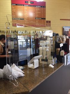 there is a counter in the restaurant with items on it and people standing at the counter